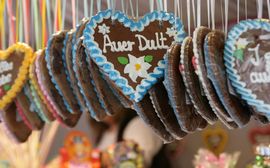 Hanging gingerbread hearts with colourful sugar decoration and the writing "Auer Dult".
