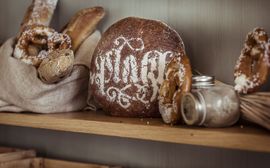 Sustainably produced baked goods such as pretzels and sourdough bread on a shelf.
