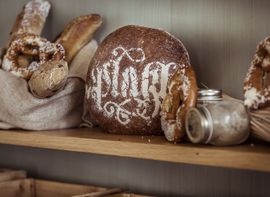 Nachhaltig produzierte Backwaren wie Brezen und Sauerteig-Brot in einem Regal.