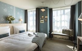 A double room in beautiful blue tones and light curtains at Marias Platzl.