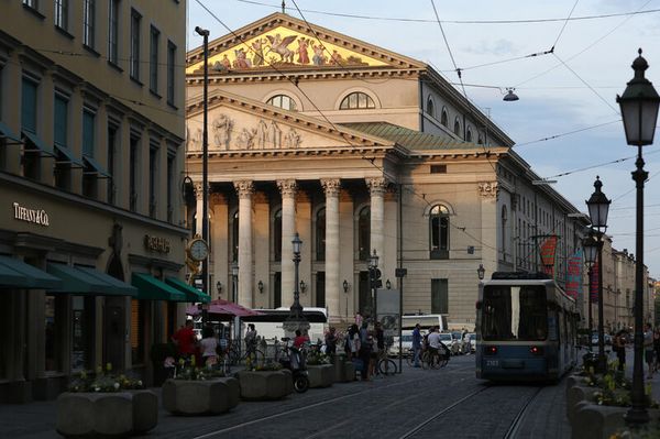 Blick auf eine Straßenbahn in der Theatinerstraße in München, mit der bayrischen Staatsoper im Hintergrund.