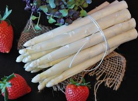 Bunch of white asparagus garnished with strawberries.