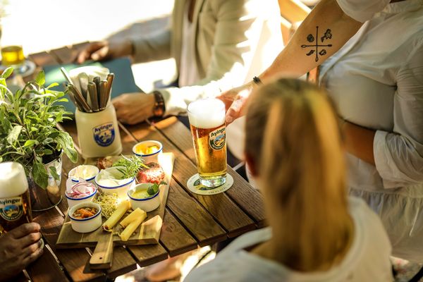 Brunch mit Bier im Platzl, Frau sitzt und wird vom Kellner bedient